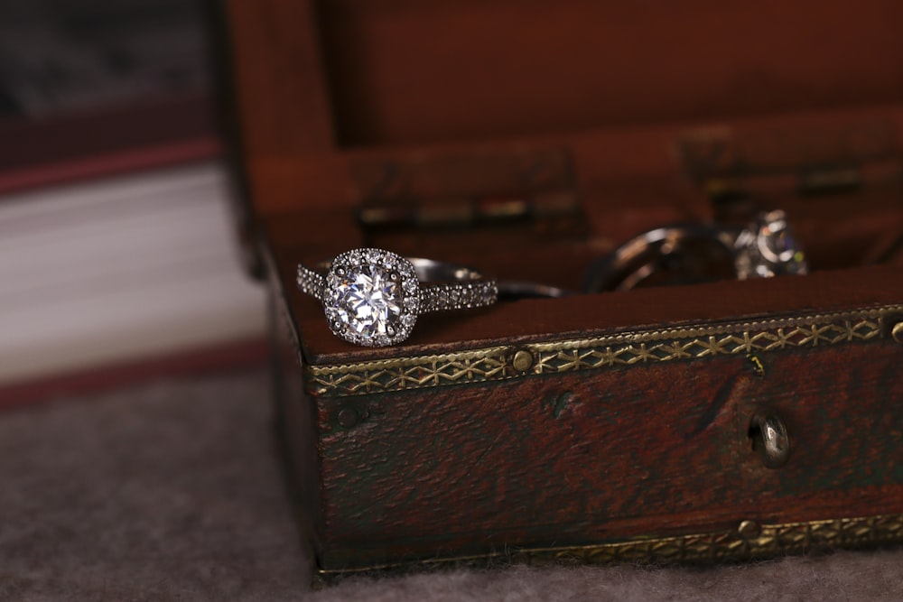 Anillo de diamantes de plata en caja de madera marrón