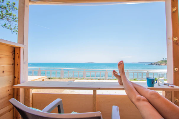 Couple relaxing in a cozy cabin with a balcony overlooking the endless blue sea.