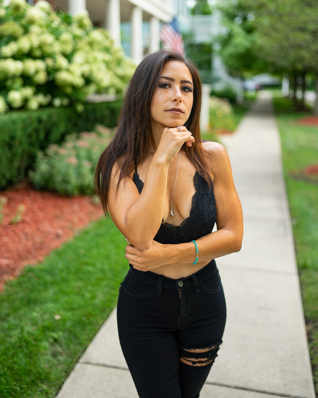 woman in black tank top and black pants standing near green plants during daytime