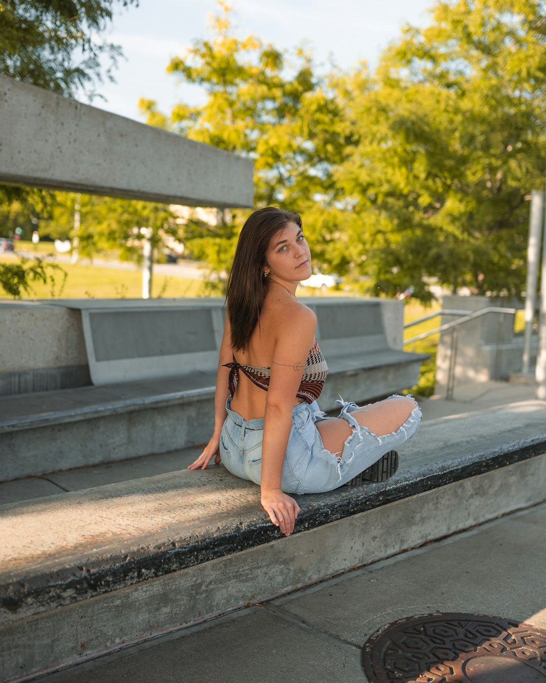 woman in white and black bikini sitting on concrete bench during daytime