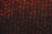 A close-up view of a sheet of bubble wrap with a dark, dramatic lighting. Each bubble is illuminated with an intense red and black contrast, highlighting the texture and translucency of the material.