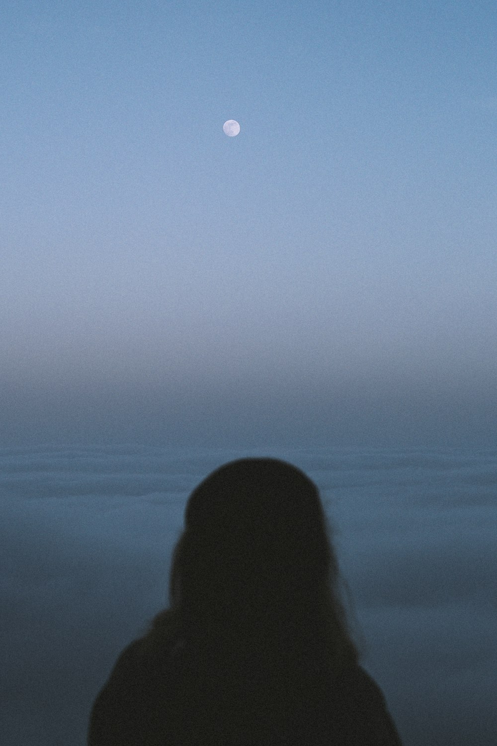 silhouette di donna sotto il cielo blu durante il giorno