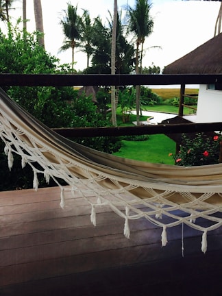 A peaceful terrace with a hammock overlooking lush greenery and distant sea.