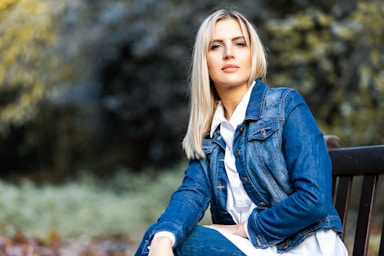 photography poses for women,how to photograph model: raminta rusteikaite | instagram: @rami.rrus | contact info@edwardhowell.photography for information.; woman in blue denim jacket sitting on brown wooden bench during daytime