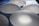 Several translucent, oval-shaped silicone implants are arranged on a textured blue surface, casting soft shadows.