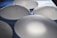 Several translucent, oval-shaped silicone implants are arranged on a textured blue surface, casting soft shadows.