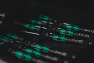 A set of black and green handled screwdrivers organized in a tool case. The handles have a distinctive design with green sections, and the name 'Wera' is visible along with the sizes on the shafts.