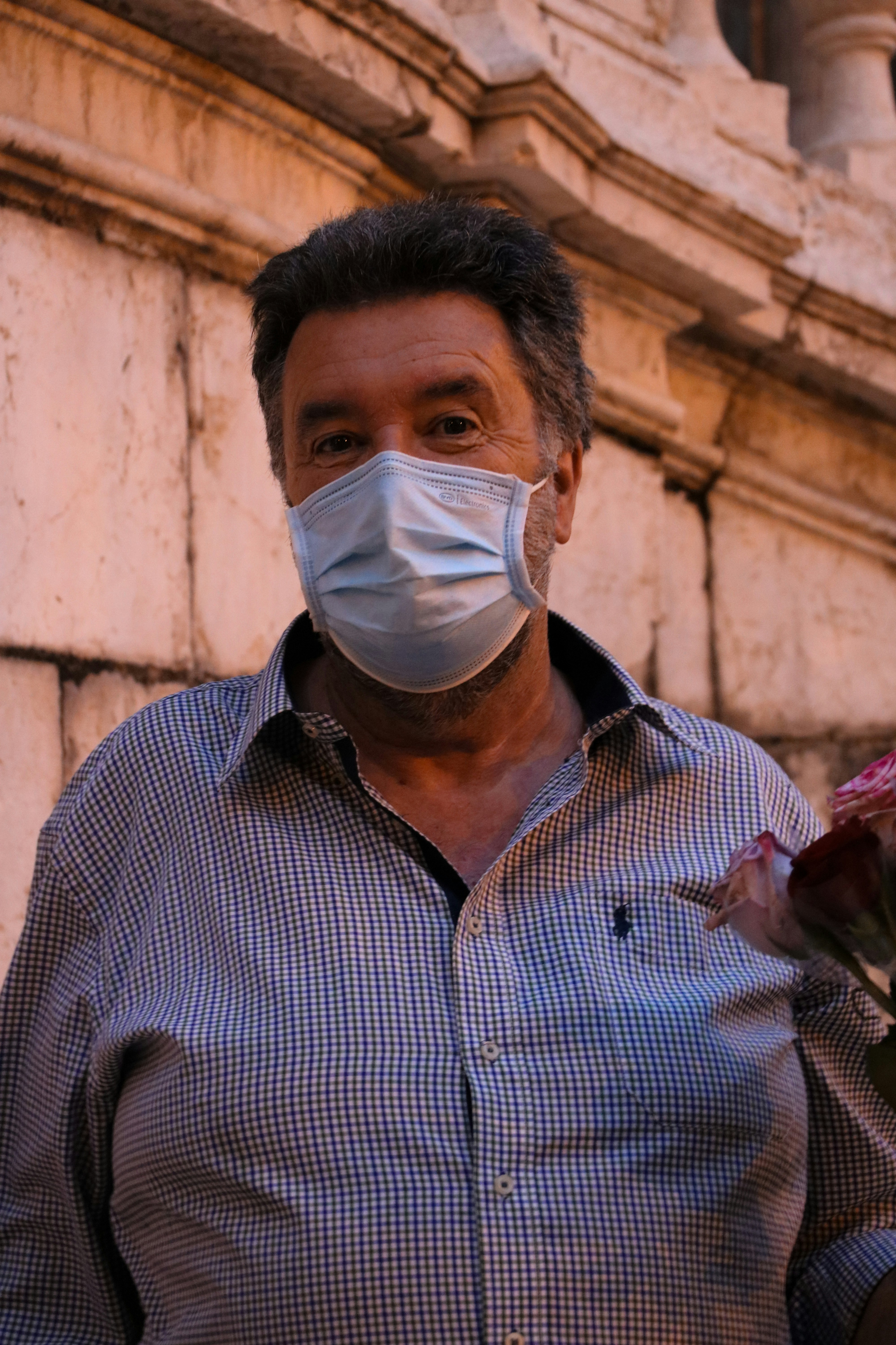 man in blue and white checkered button up shirt with white face mask