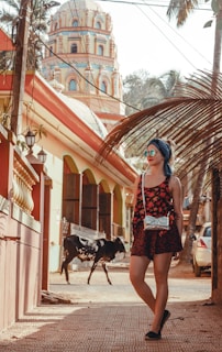 woman in white and black floral dress standing beside black horse during daytime