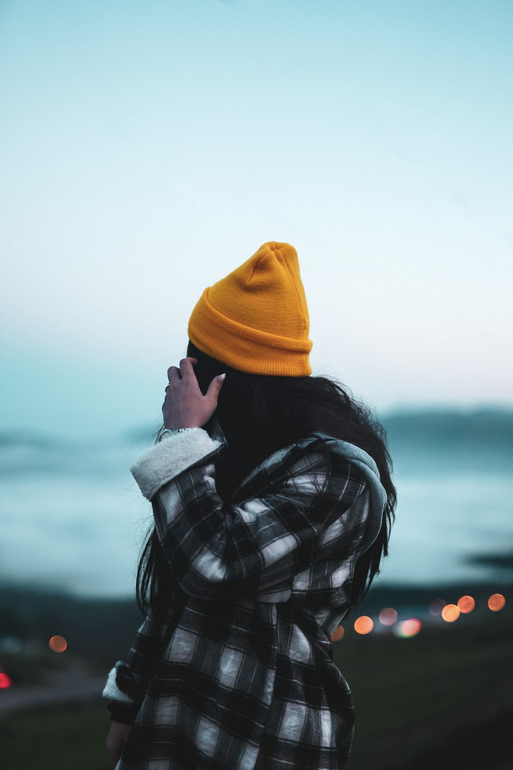 person in black and white plaid shirt and yellow knit cap