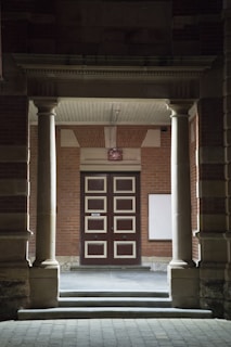A welcoming office entrance of Ducapa with natural stone walls and wooden door.