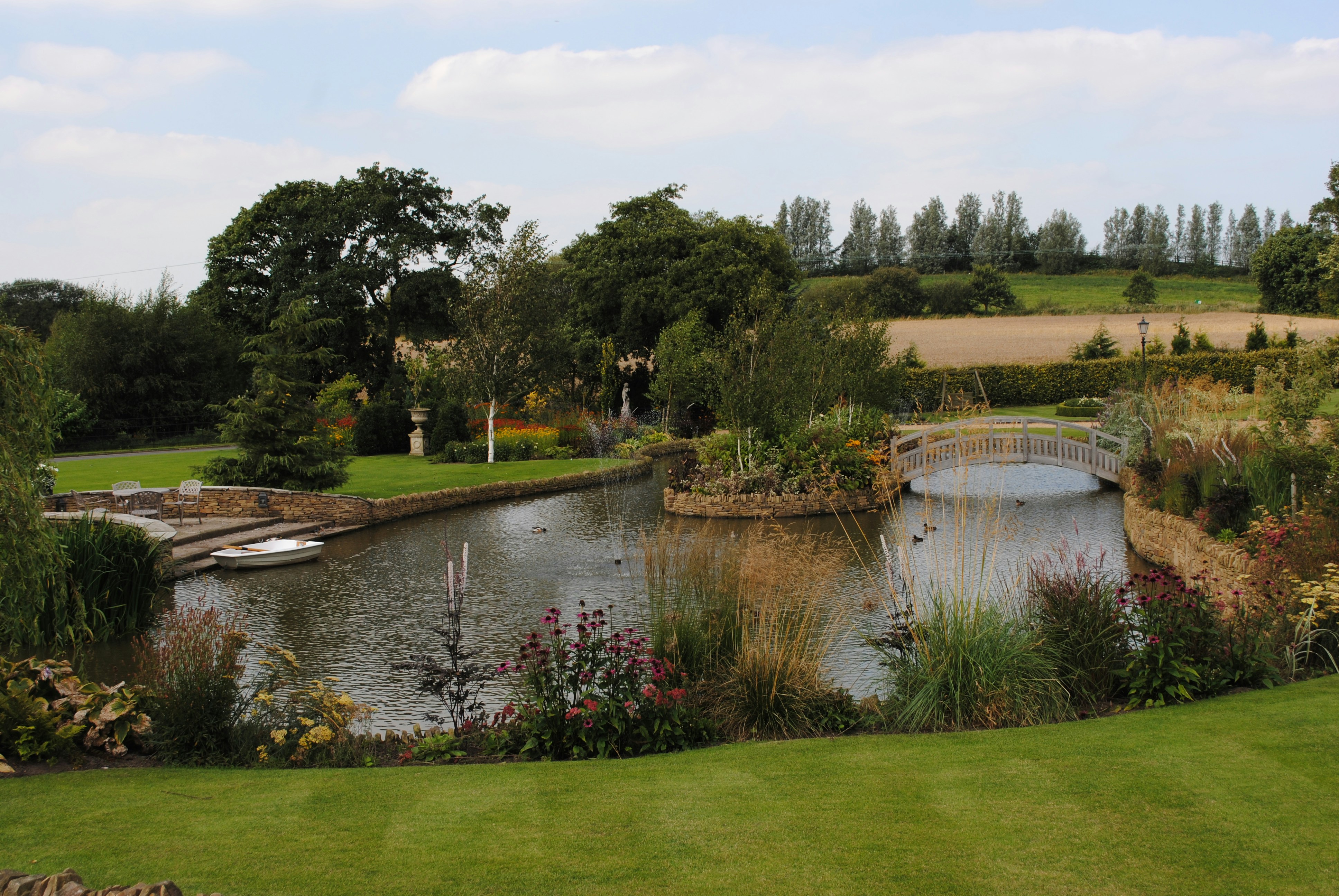 Garden pond with plantings and a green lawn