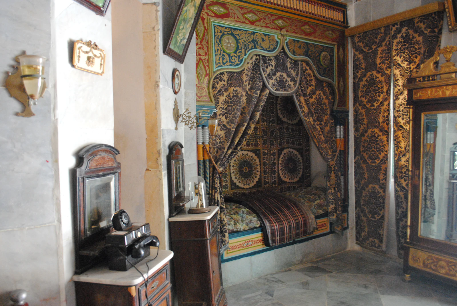 Fauteuil en bois sculpté avec coussins floraux dans une suite chaleureuse.