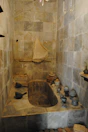 Bathroom featuring natural stone tiles and a deep soaking tub.