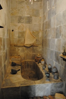 Spacious bathroom featuring a clawfoot tub and natural stone tiles