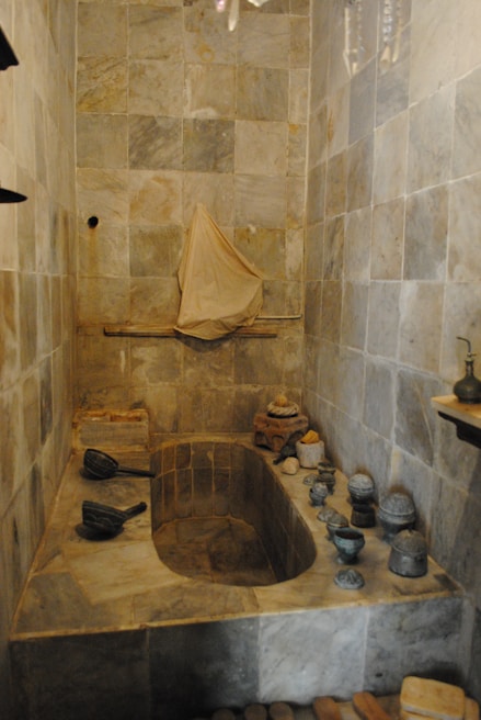 Spacious bathroom featuring a clawfoot tub and natural stone tiles