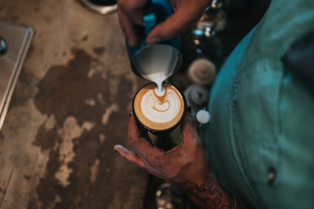 person holding white and brown cup