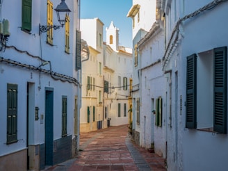 empty street between concrete houses during daytime