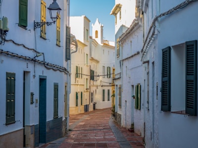 empty street between concrete houses during daytime