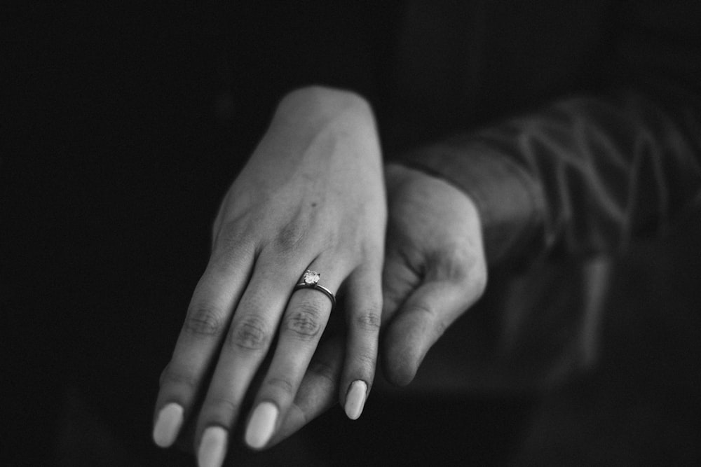 grayscale photo of person wearing ring