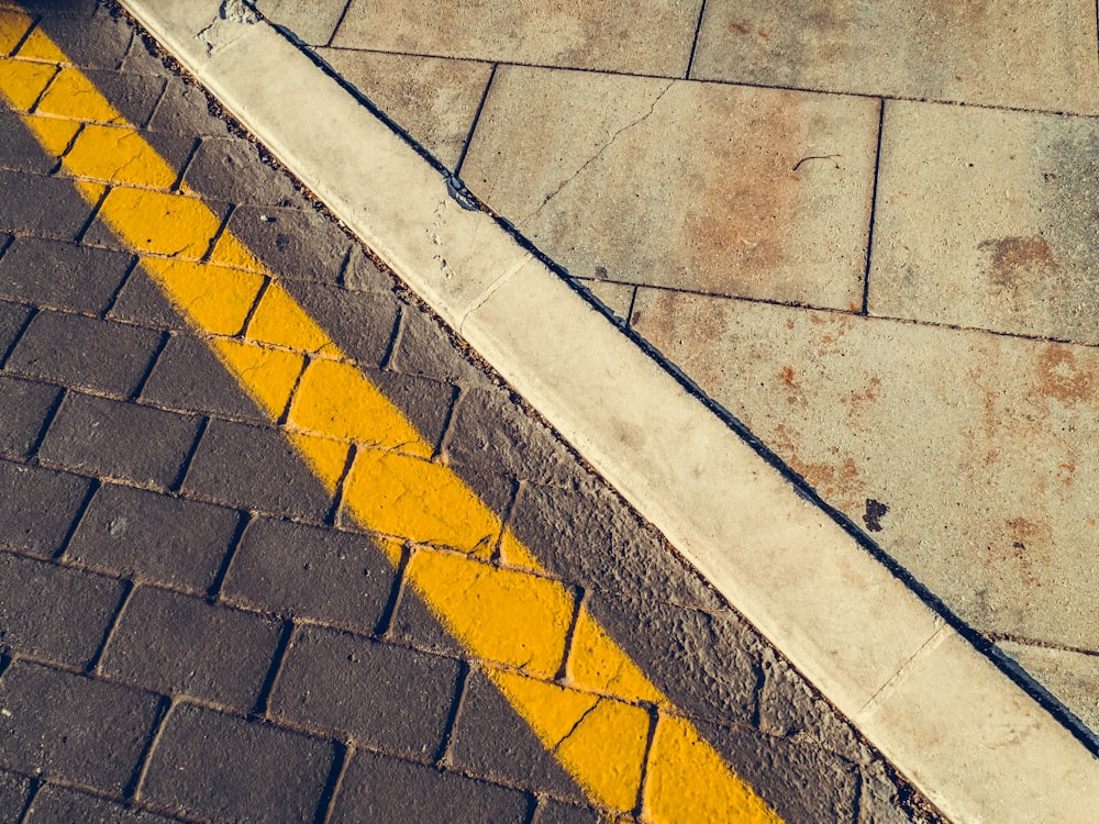 pavimento de hormigón gris con línea amarilla y blanca