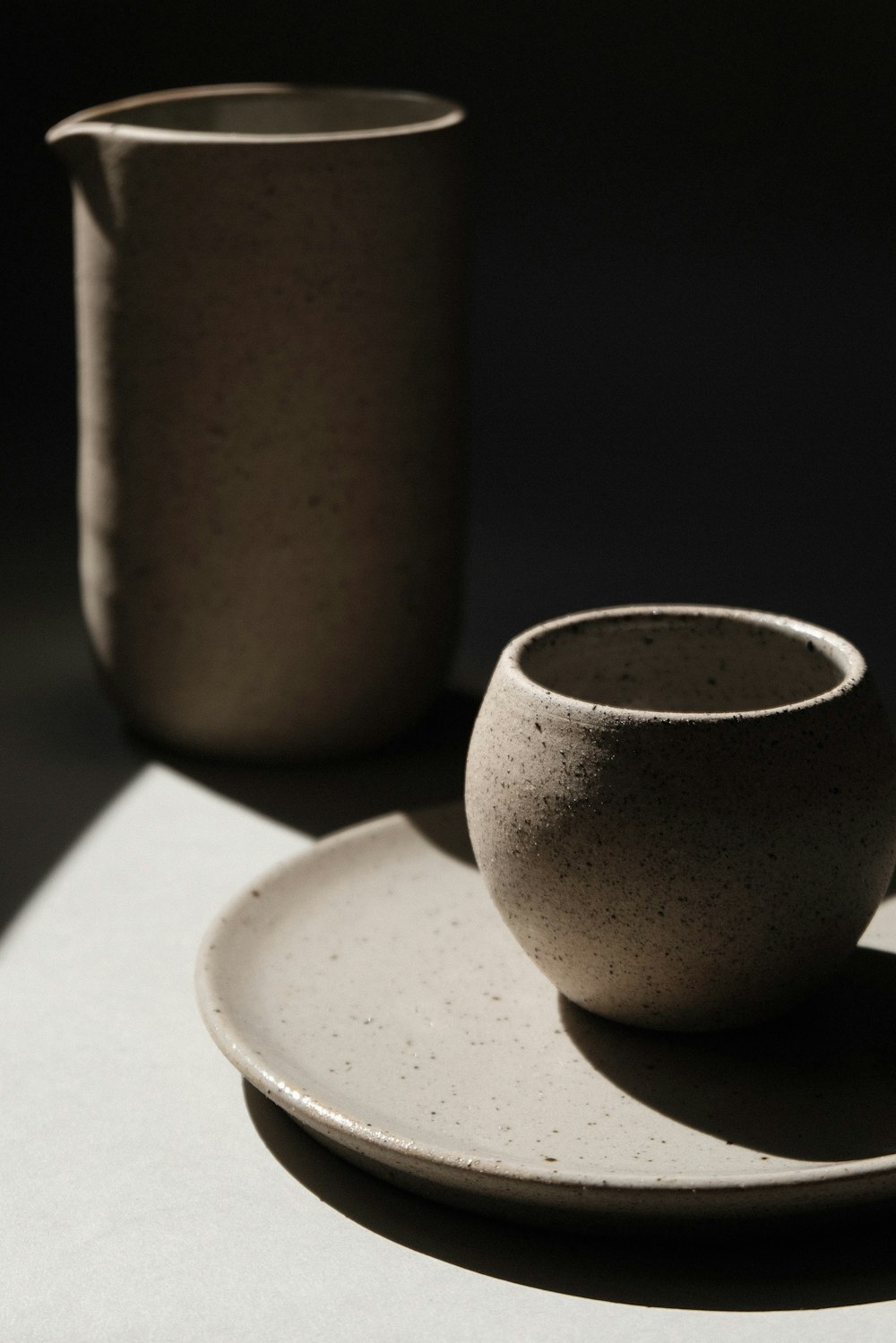 copo de cerâmica marrom no pires de cerâmica branco