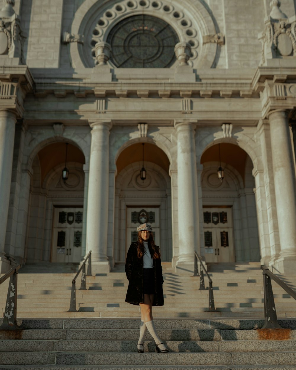 woman in black dress standing on gray concrete floor during daytime