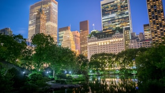 A serene view of the Runwal Lands End residential towers illuminated at dusk, surrounded by lush greenery.