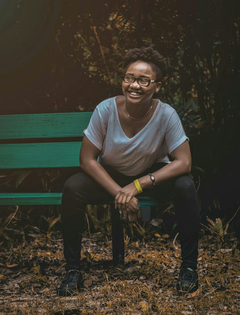 man in gray crew neck t-shirt sitting on brown wooden bench