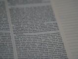 An open book with text printed on both visible pages. The left page contains paragraphs with varying sizes of text, and some words are in bold. The right page has sections of blank lines that appear to be for notes or annotations. The text is in English.