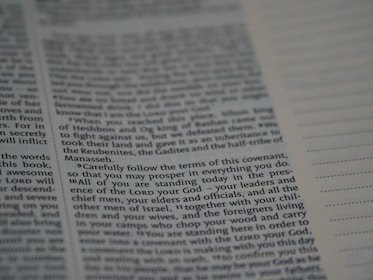 An open book with text printed on both visible pages. The left page contains paragraphs with varying sizes of text, and some words are in bold. The right page has sections of blank lines that appear to be for notes or annotations. The text is in English.