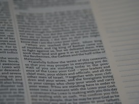 An open book with text printed on both visible pages. The left page contains paragraphs with varying sizes of text, and some words are in bold. The right page has sections of blank lines that appear to be for notes or annotations. The text is in English.