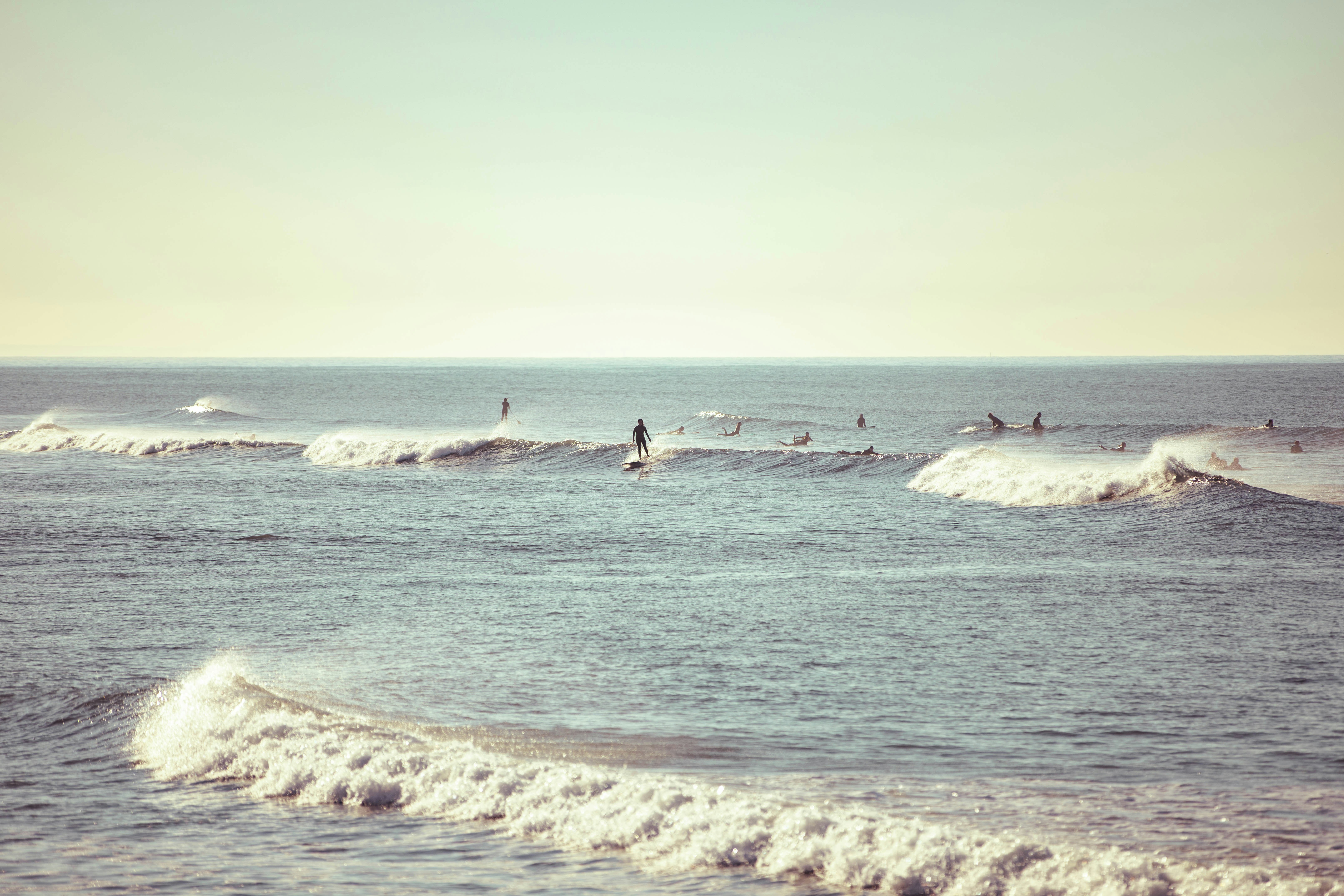 pessoas surfando nas ondas do mar durante o dia