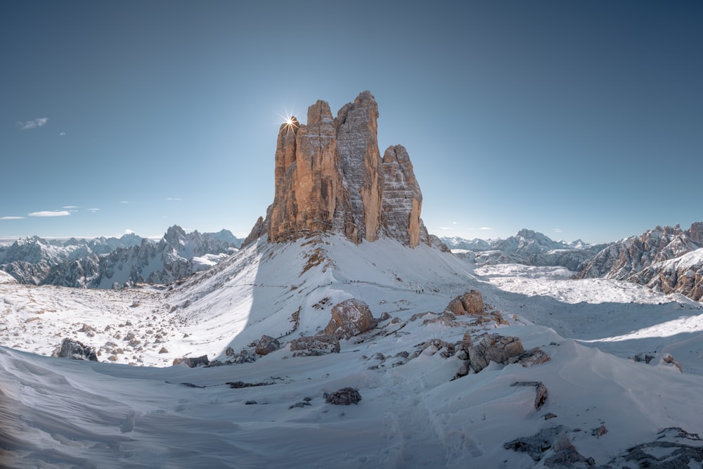 brown rocky mountain covered by snow under blue sky during daytime