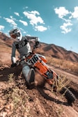 man in black helmet riding orange and black atv
