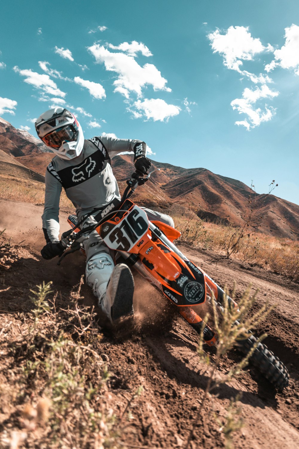 Homme au casque noir conduisant un VTT orange et noir