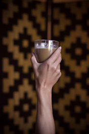 person holding clear drinking glass