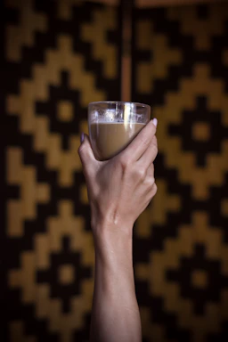 person holding clear drinking glass