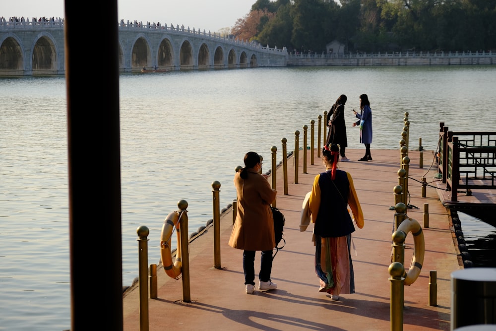 man and woman walking on wooden dock during daytime