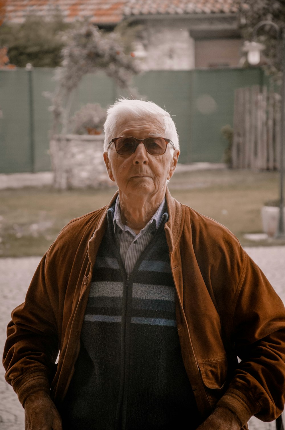 man in brown jacket wearing black framed eyeglasses