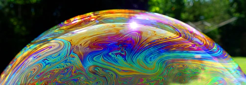 Close-up of a vibrant bottle of ultrabeezie laundry liquid soap with fresh bubbles around it.