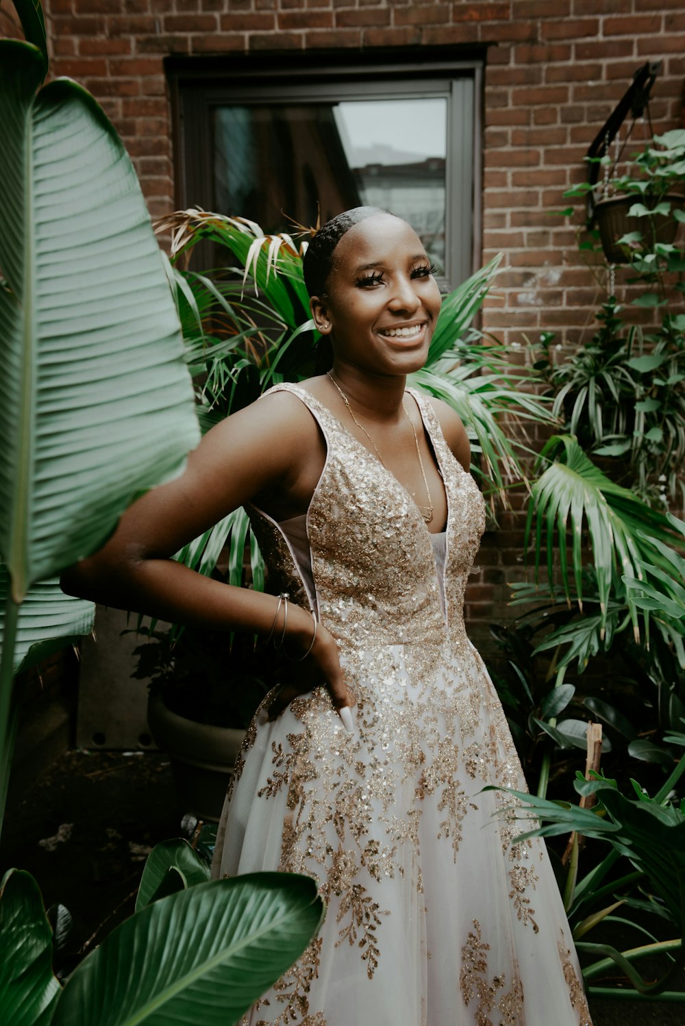 woman in white floral sleeveless dress standing near green plant