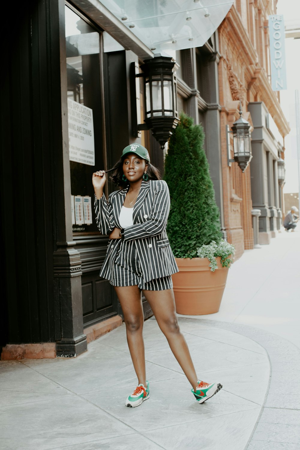 woman in black and white stripe long sleeve dress standing on sidewalk during daytime