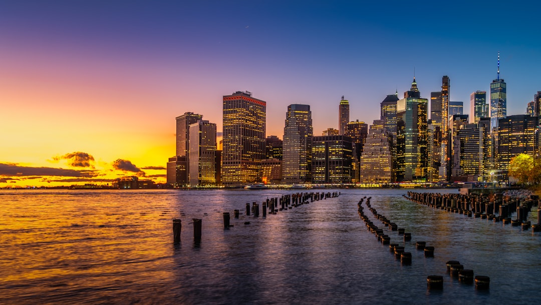 city skyline across body of water during night time