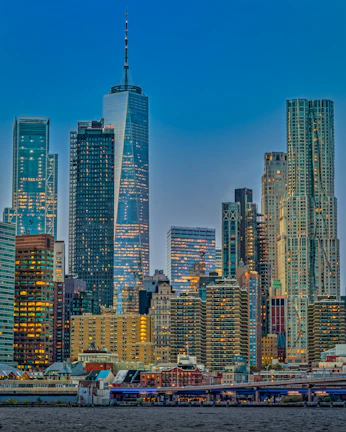Cityscape at dusk featuring illuminated skyscrapers reflecting a global marketplace.