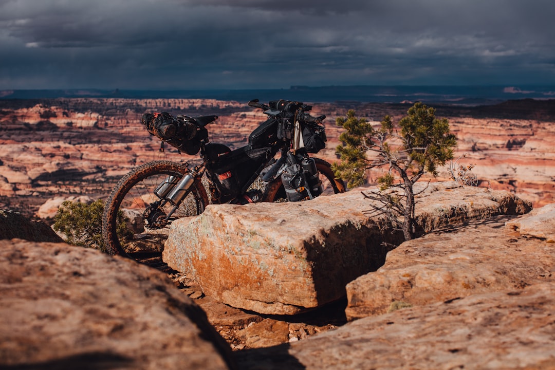 black mountain bike on brown rocky field under gray cloudy sky during daytime