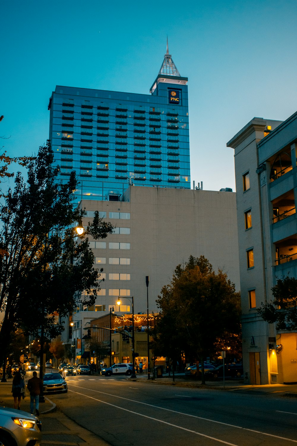 white concrete building near green trees during night time