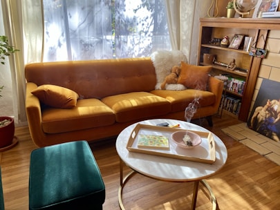 A cozy living room featuring a second-hand sofa and decorative items.