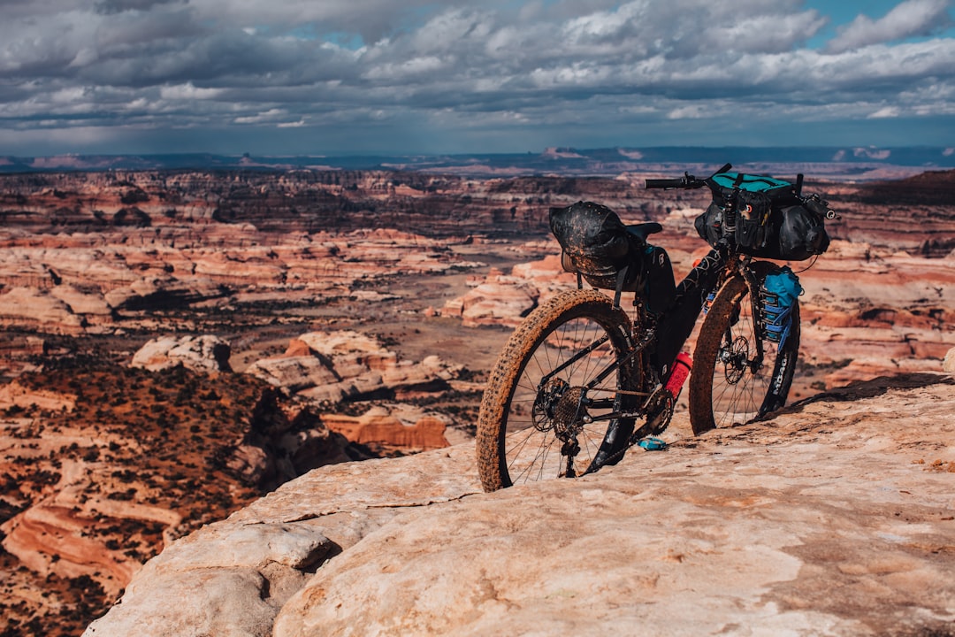 man in black jacket and black pants riding black mountain bike on brown rocky mountain during