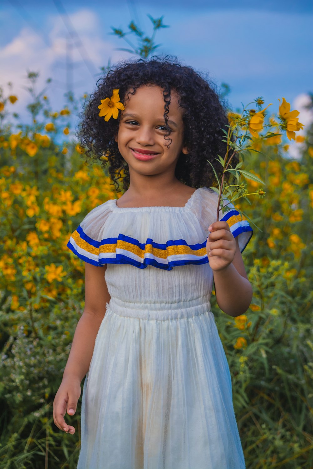 girl in white and blue dress holding blue bottle